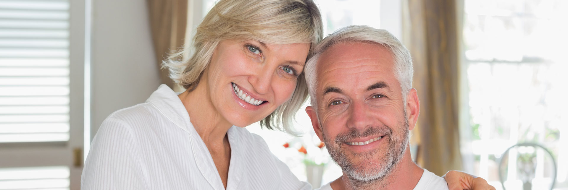 Smiling senior couple who had a dental implants treatment